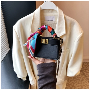Detail view of mini chain handbag with a silk scarf handle and golden twist lock