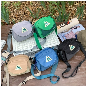 Close-up of colorful nylon messenger bags for kids in gray green black khaki and blue