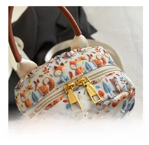 Close-up of smooth dual golden zippers and fox print on a canvas backpack
