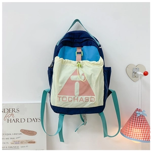 Close-up of color-block nylon backpack featuring drawstring pockets and brand lettering