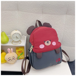 Detail view of cartoon bear backpack for kids with red and grey contrast design