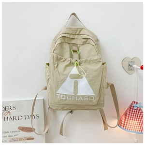 Detail of khaki kids backpack with lime green zipper cord and TOCHASO logo on pocket