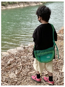 Vue détaillée du sac bandoulière enfant vert avec mesh et sangle tressée en extérieur