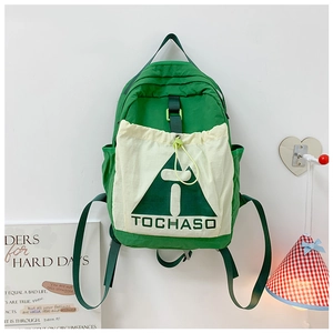 Close-up of durable green nylon kids backpack featuring white drawstring front pocket