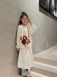 Dettaglio borsa rossa da bambina in pelle con ciondolo a cucciolo e inserti oro