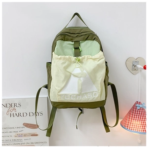 Detail of kids backpack featuring contrast olive green and yellow colors with front drawstring pocket