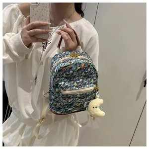 Mirror selfie showing the fit of a mini ocean theme backpack with sea shell prints
