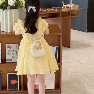 Robe jaune fille avec broderies fleurs et mini sac à main en forme de demi-lune blanc