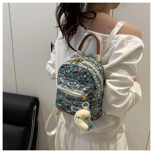 Detail of nautical print backpack featuring sea shells and plush moon pendant