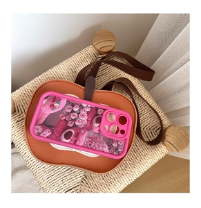 Dettaglio della mini borsa a tracolla a forma di mela in pelle marrone con cinturino