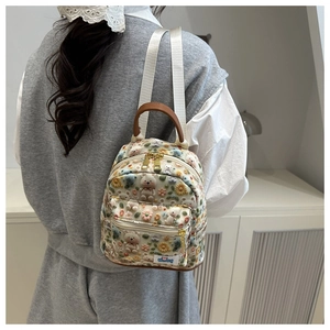 Detail of a mini backpack with 3D plush flowers, bear doll, and LUCKY! blue label