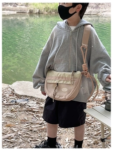 Détail du sac à bandoulière enfant en nylon beige avec sangle en corde orange