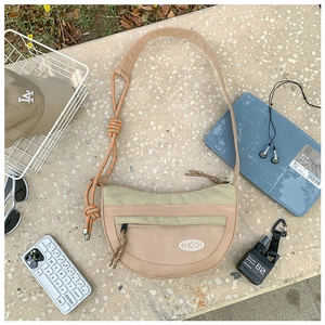 Détail du sac croissant en nylon kaki avec poche filet et décor de corde orange