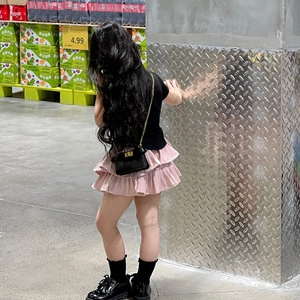 Girl's stylish outfit featuring a pink tiered cake skirt and a black chain shoulder bag