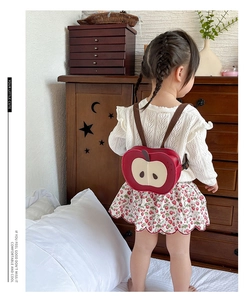 Zainetto rosso a forma di mela per bambini con spallacci regolabili indossato da una bimba