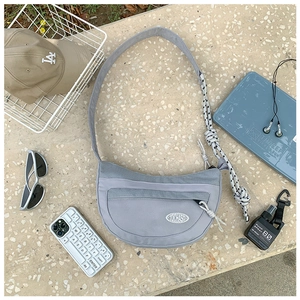 Détail du sac croissant gris en nylon avec texture mesh et bandoulière en corde tissée