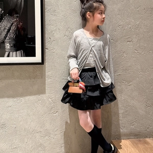 Mini brown kids' handbag with silk scarf and chain strap shown in a stylish autumn outfit