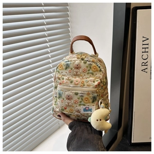 Detail of cream mini backpack with bear embroidery, brown handle and moon pendant