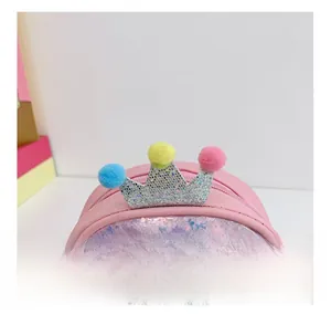 Close-up of pink sequin bag featuring a glittery silver crown and colorful pom-poms