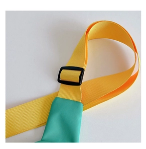 Detail of adjustable yellow nylon strap with black matte buckle on green kids car chest bag