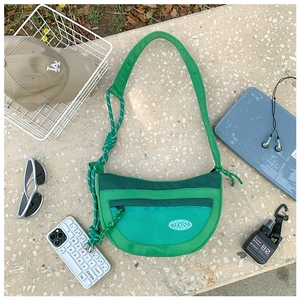 Détail d'un sac bandoulière vert pour enfants en maille avec sangle de sport