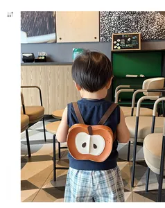 Dettaglio dello zaino a forma di mela per bambini in pelle marrone indossato