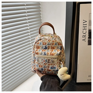 Close-up of mini backpack with fox print, golden zippers and plush moon charm