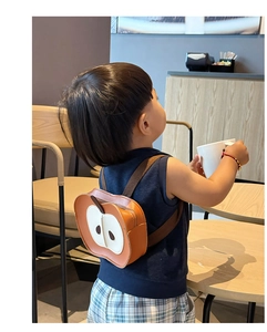 Dettaglio dello zaino per bambini a forma di mela con spallacci regolabili in un caffè accogliente