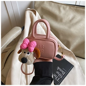 Dettaglio borsa rosa da bambina in pelle con lettere in rilievo e ciondolo a forma di cane