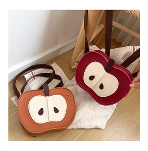 Dettaglio di zaini a forma di mela per bambini in arancione e rosso con cinghie regolabili