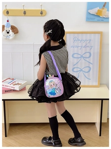 Detail of sequin girl's crossbody bag featuring cartoon characters and crown decor