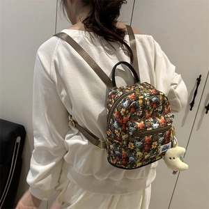 Mini cartoon backpack with colorful Pokemon print and moon plush charm on model