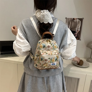 Cute cartoon mini backpack with bear embroidery and flower patterns on beige fabric