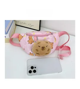 Rosa Comic-Gürteltasche mit Plüsch-Capybara und Handy als Größenvergleich auf dem Tisch