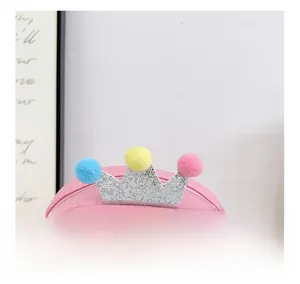 Detail of pink cartoon bear crossbody bag with glitter crown and colorful pom-poms