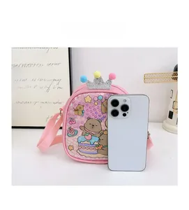 Pink cartoon cross-body bag for kids shown next to a smartphone for scale reference