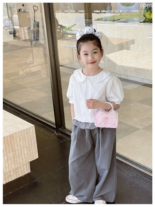 Girl modeling pink lace bow handbag with pearl handle and stylish children's outfit