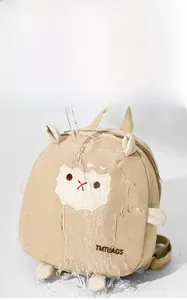 Détail imperméable du sac à dos enfant beige avec mouton brodé et design mignon