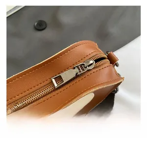 Close-up of premium metal zipper and fine stitching on the brown leather apple bag