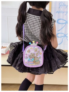 Detail of purple crossbody bag for kids with cute bear print and glitter crown decoration