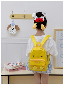 Detail view of yellow duck kids backpack featuring a transparent pocket with plush toys