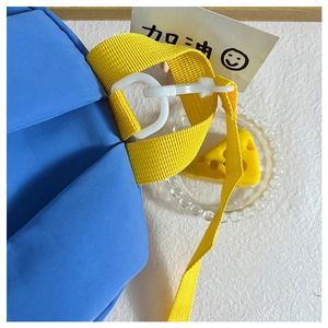 Détail en nylon bleu avec sangle jaune et crochet blanc sur le sac à dos enfant