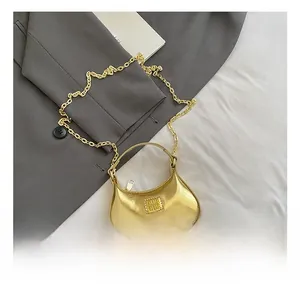 Détail du sac à chaîne doré métallisé avec plaque logo et mini poignée élégante