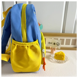 Détail du sac à dos enfant bleu et jaune avec poche latérale et texture en nylon