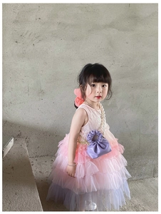Detail of a purple pleated mini bucket bag paired with a layered lace princess dress