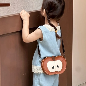 Mini apple-shaped PU leather crossbody bag for kids shown on a small child