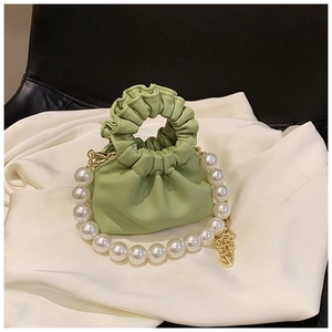 Macro detail of mint green pleated mini bag with pearl chain and circular handle