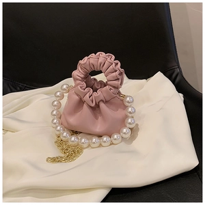 Detail showing the light pink pleated texture and large white pearls on this mini bucket bag
