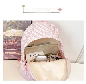 Detail view showing large interior capacity of pink checkered backpack with laptop compartment