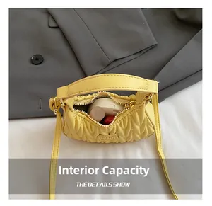 Internal capacity of yellow quilted mini shoulder bag showing lipstick and makeup